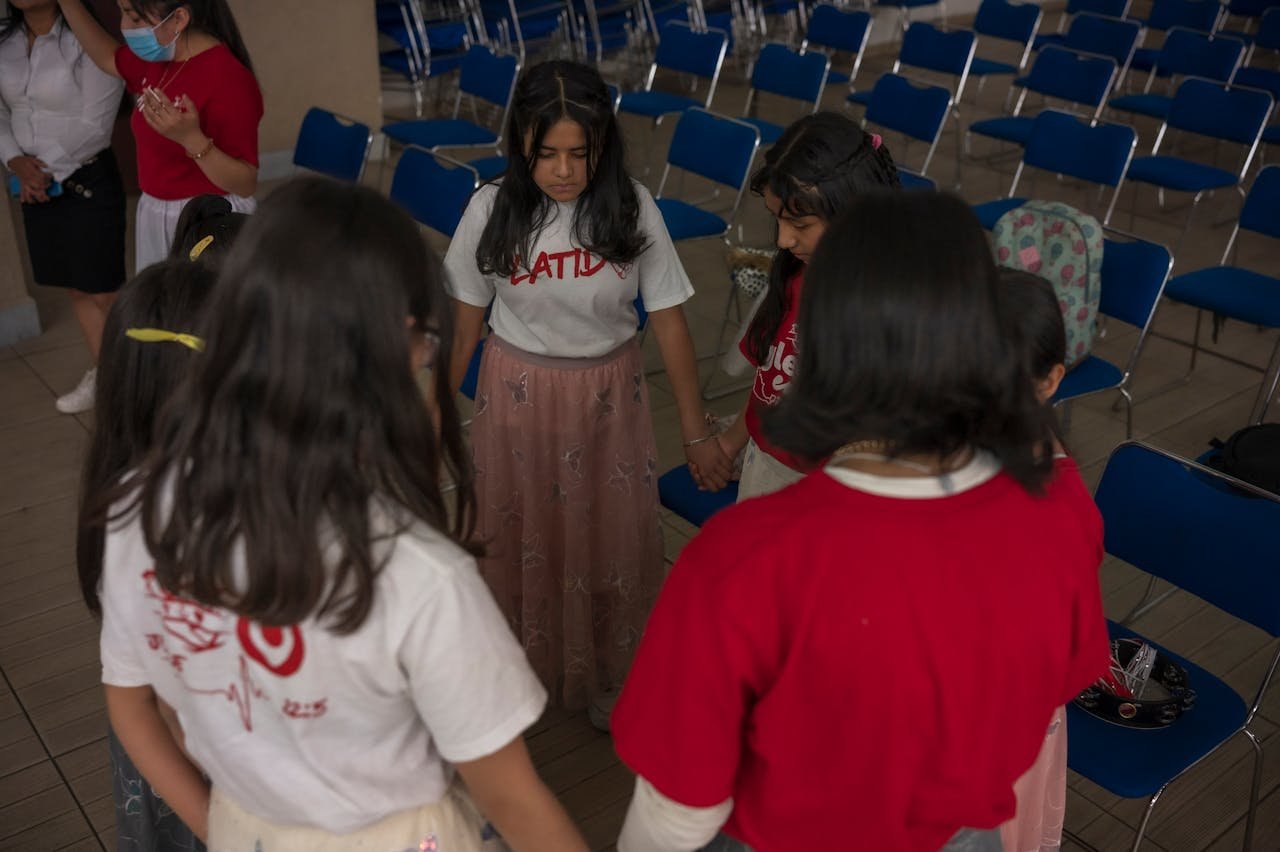 Girls Holding Hands in a Circle, in an Auditorium